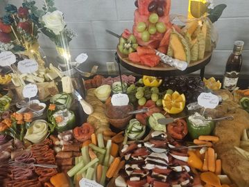 A lavish grazing table spread with fruits, cheeses, vegetables, and dips.