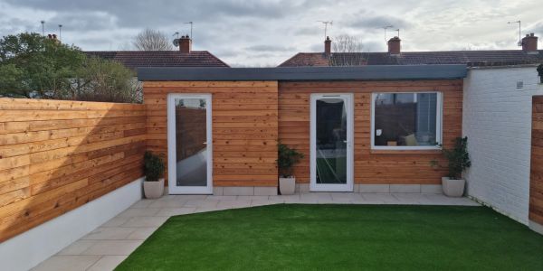 Modern backyard with wooden shed and artificial grass.