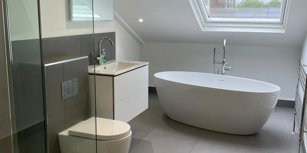 Modern bathroom with freestanding tub and skylight.