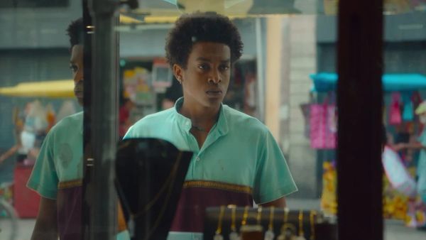 Young man looking thoughtfully at jewelry in a shop window.