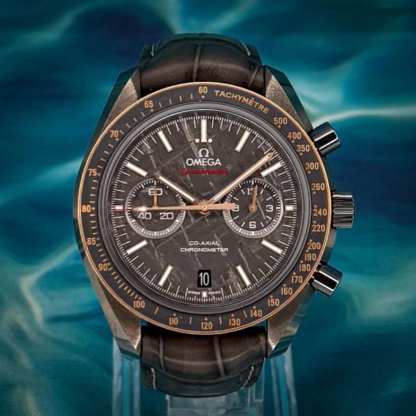 Close-up of a luxury Omega Speedmaster wristwatch with a dark dial and leather strap.