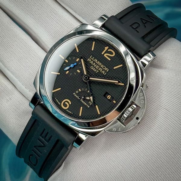 Close-up of a Panerai Luminor GMT wristwatch with black rubber strap.