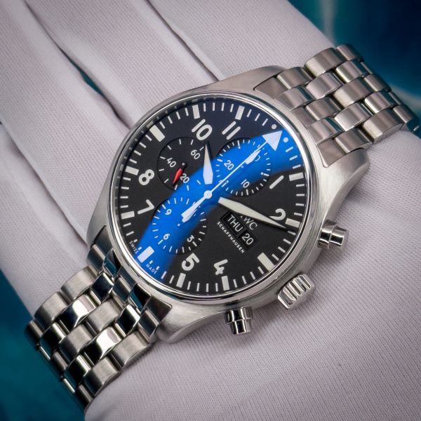 Elegant silver wristwatch with black dial and blue reflection.