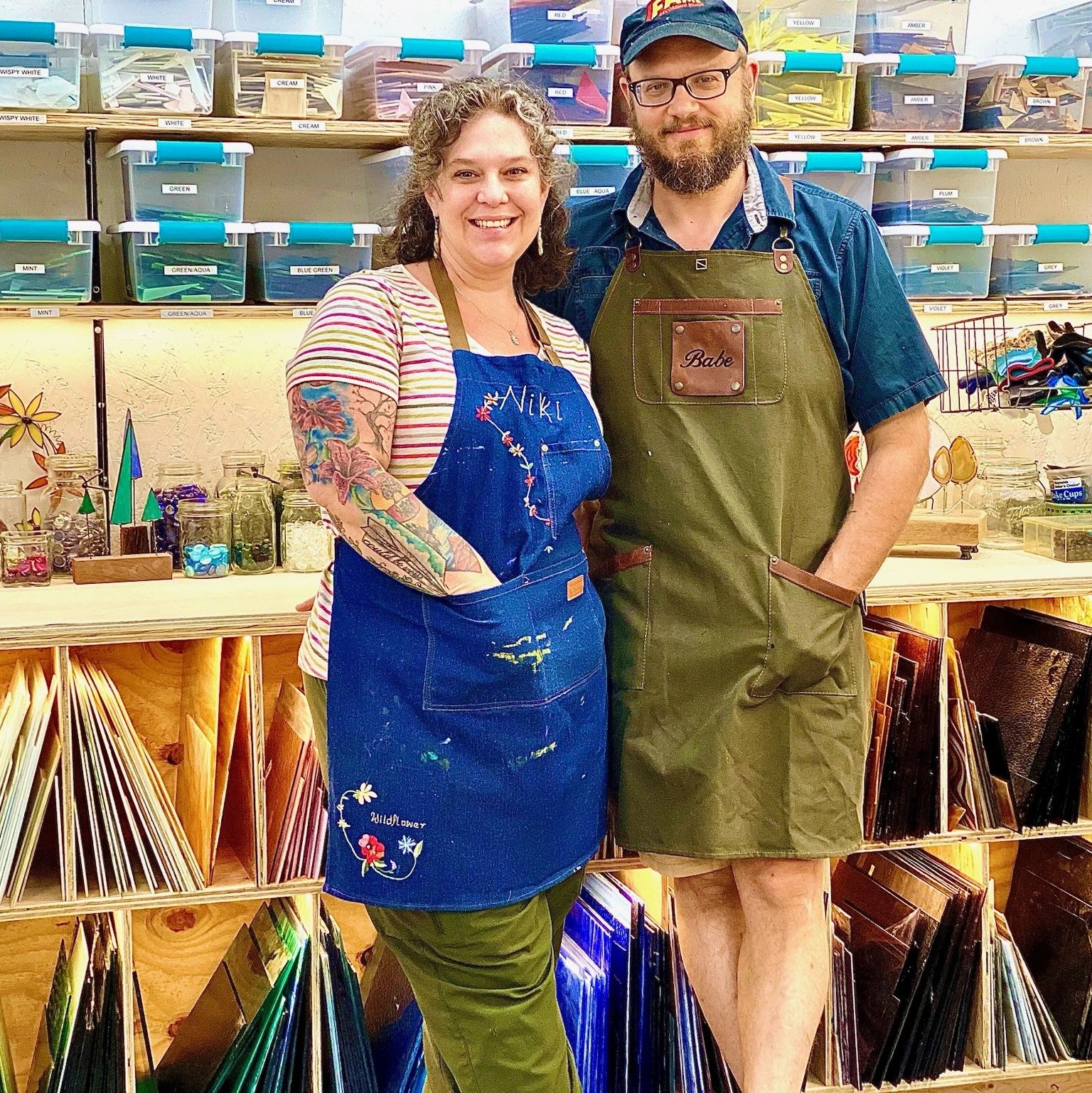 Studio owners Nikki Noel and Tim Frey in Wildflower Studio wearing work aprons