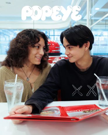 Couple smiling at each other in a diner.