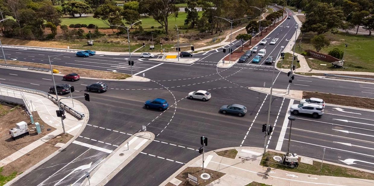 A large urban intersection with multiple lanes and traffic signals.