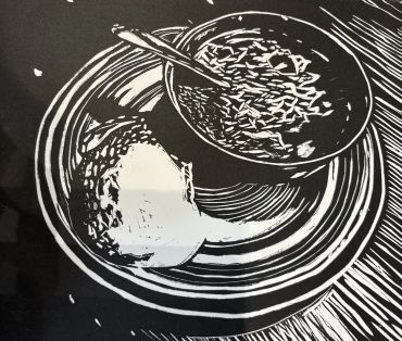 Black and white art of a bowl with spoon and bread on a plate.