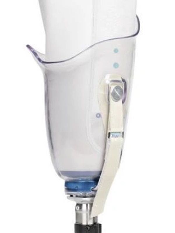 Transparent prosthetic leg socket with adjustable strap and metal connector.