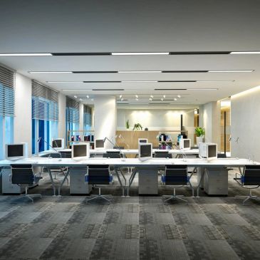 Modern open-plan office with computers and chairs.