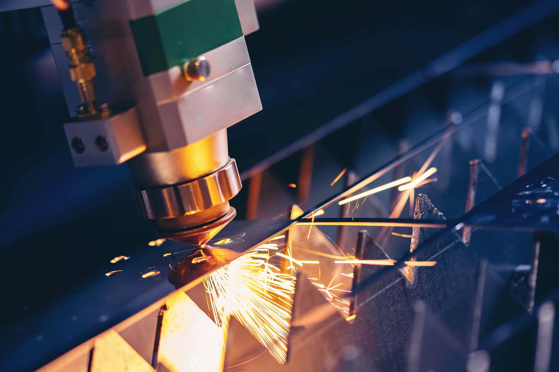 Close-up of a laser cutting machine slicing metal with sparks flying.
