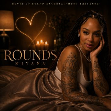 Woman with tattoos posing on bed with warm lights and heart shape.