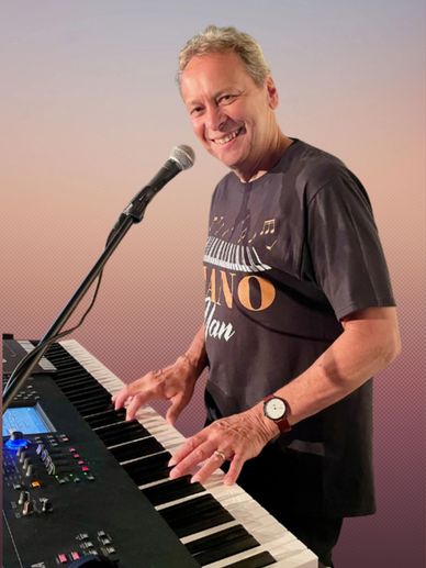 Man smiling while playing keyboard and singing into a microphone.