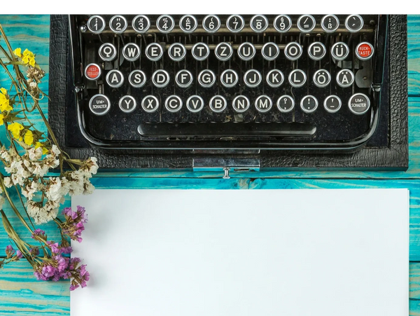 typewriter with paper and flowers