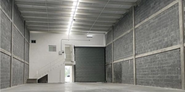 Interior de un almacén vacío con paredes grises.