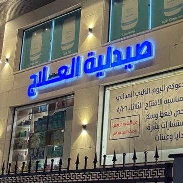 واجهة صيدلية بالعربية مضاءة في الليل.