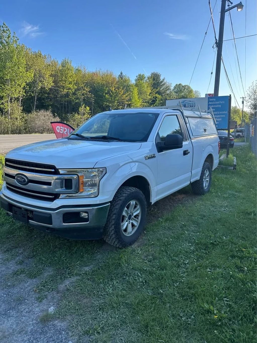 White Ford F-150 truck parked on grass.