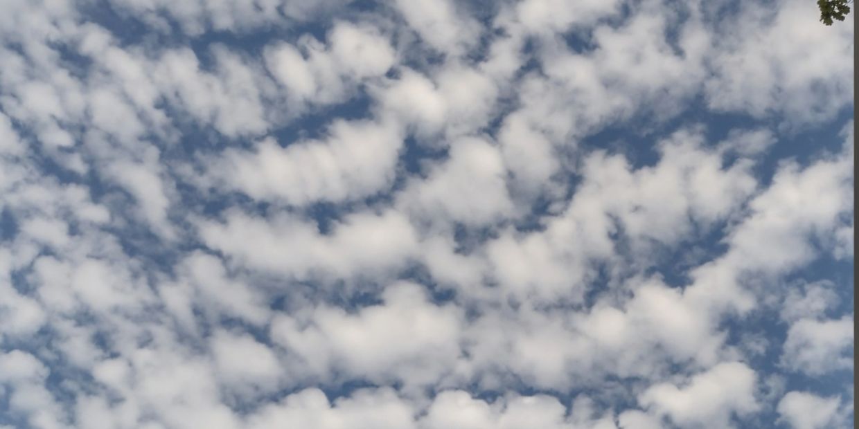 White fluffy clouds scattered across a blue sky.