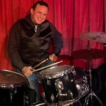 Man playing the drums with a smile.