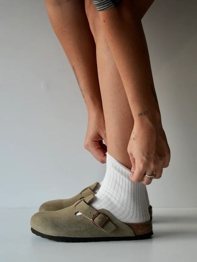 Person wearing white socks and beige shoes.