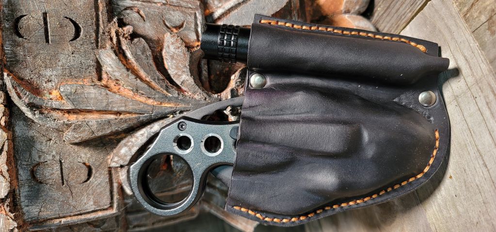 Revolver con funda negra de cuero.