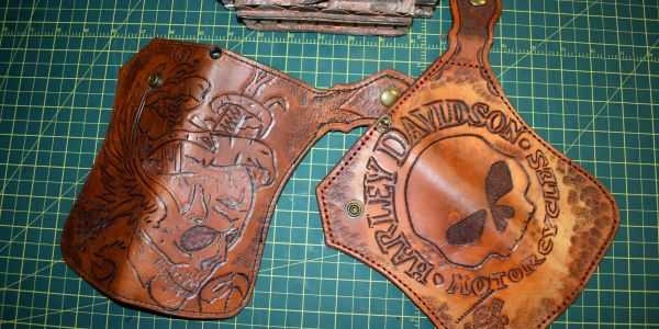 Fundas de cuero grabadas con diseños personalizados sobre una mesa.