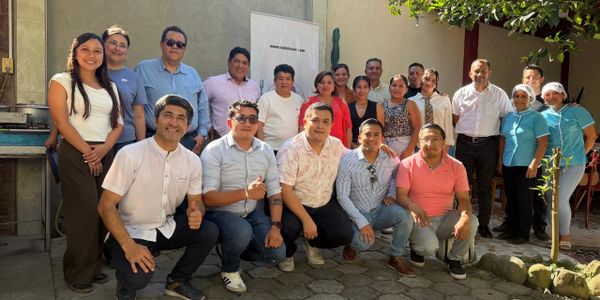 Group photo of people outdoors, smiling and posing together.