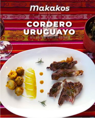 Plated Uruguayan lamb with sides on a white dish, set on a vibrant red tablecloth.