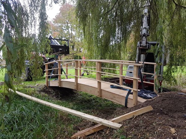 Installing bespoke oak bridge before the pond is filled
