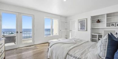Bright bedroom with ocean view and balcony access.