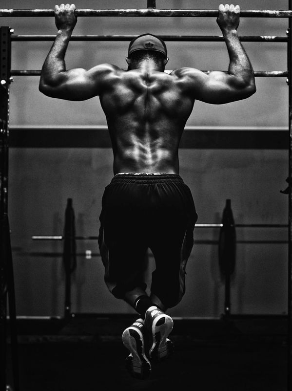 Back of strong black man doing pull ups.