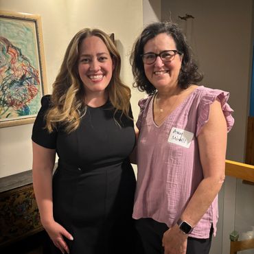 Two women smiling indoors.