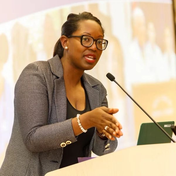 Woman speaking confidently at a podium with a microphone.