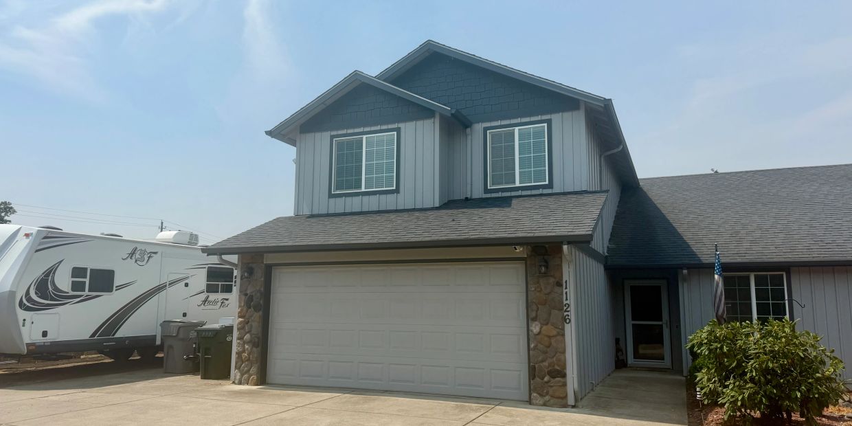 Two-story house with garage and RV parked outside.