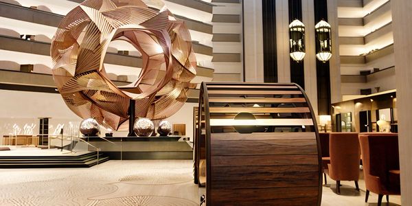Modern hotel lobby with abstract sculptures and stylish seating.