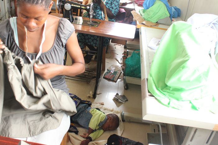 Teen mothers  undertaking vocational training as their babies rest on the mat. 