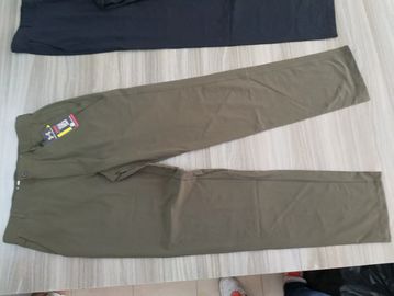Pair of olive green pants laid out on a table.