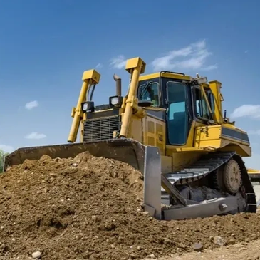 Yellow bulldozer pushing a pile of dirt.