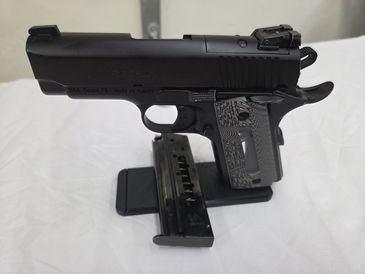 Black semi-automatic handgun with magazine placed on a white cloth.