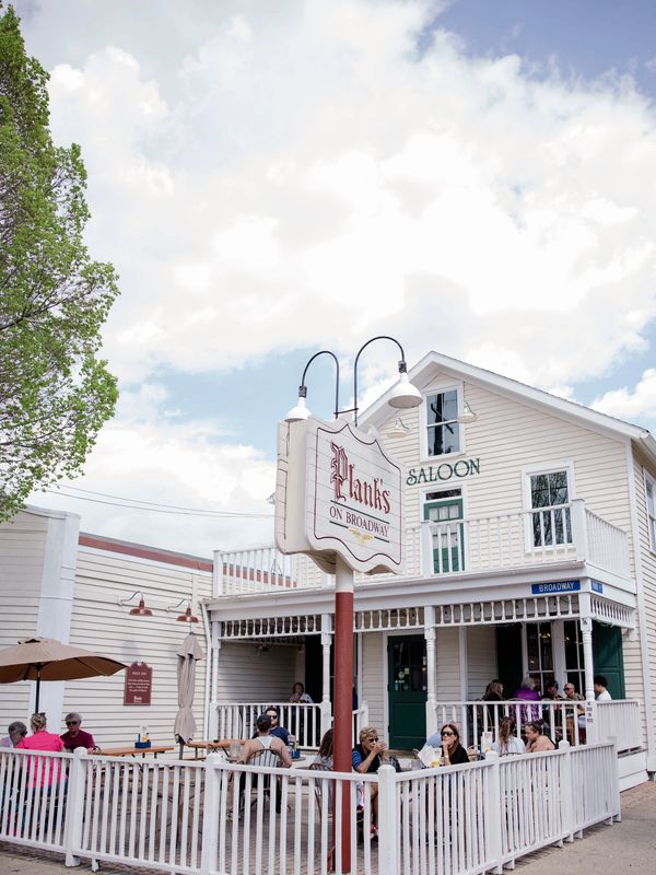 People dining outdoors at Plank's Saloon on Broadway.
