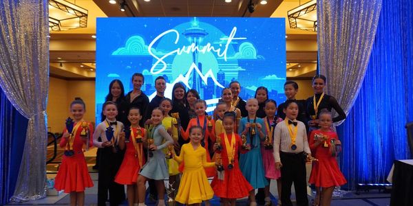 Children and adults posing with trophies and medals at a Summit event.