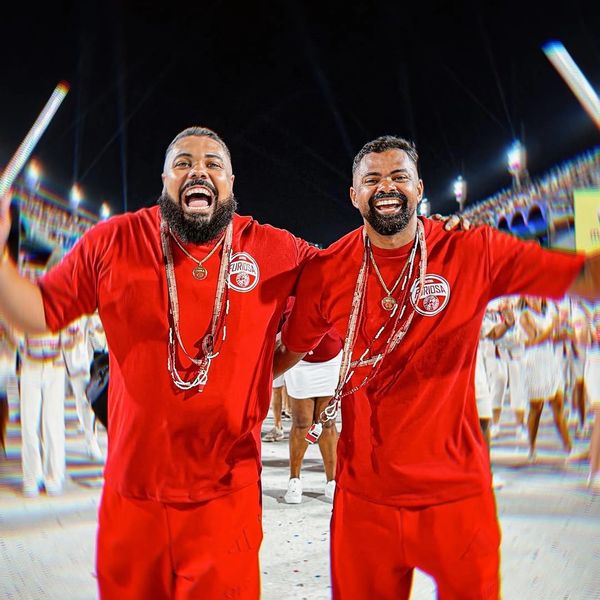 Two joyful men in red outfits celebrating at a lively event.