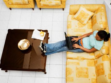 Lady in Jacksonville, Florida paying rent online to Rebate Rentals while sitting on the sofa.