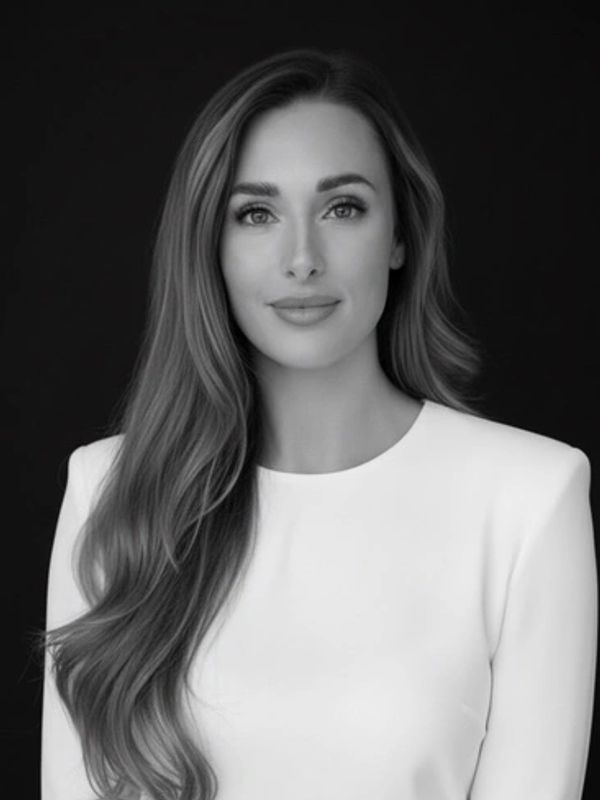Black and white portrait of a woman with long hair in a white top.