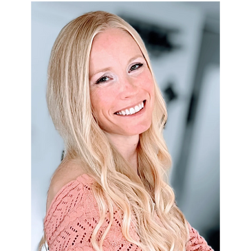 Smiling woman in a pink crochet sweater with long blonde hair.