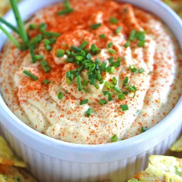 Creamy dip garnished with chopped chives and paprika.