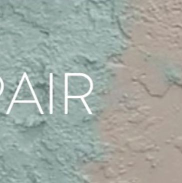 Close-up of textured wall with the word 'REPAIR' partially visible.