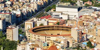 Aerial view of a bullring surrounded by city buildings.