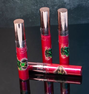 Three red lip gloss tubes with metallic caps.