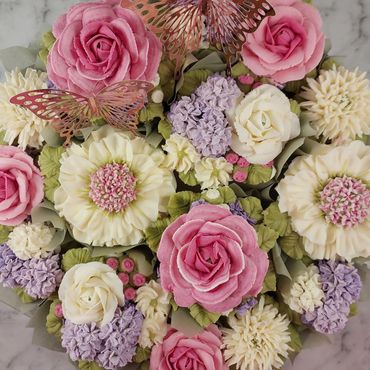 Intricate floral bouquet with pink, white, and purple flowers and decorative butterflies.