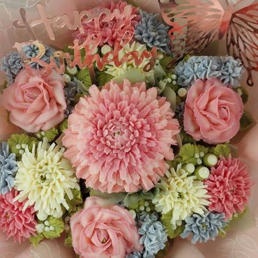 A colorful birthday flower bouquet with a metallic butterfly and Happy Birthday sign.